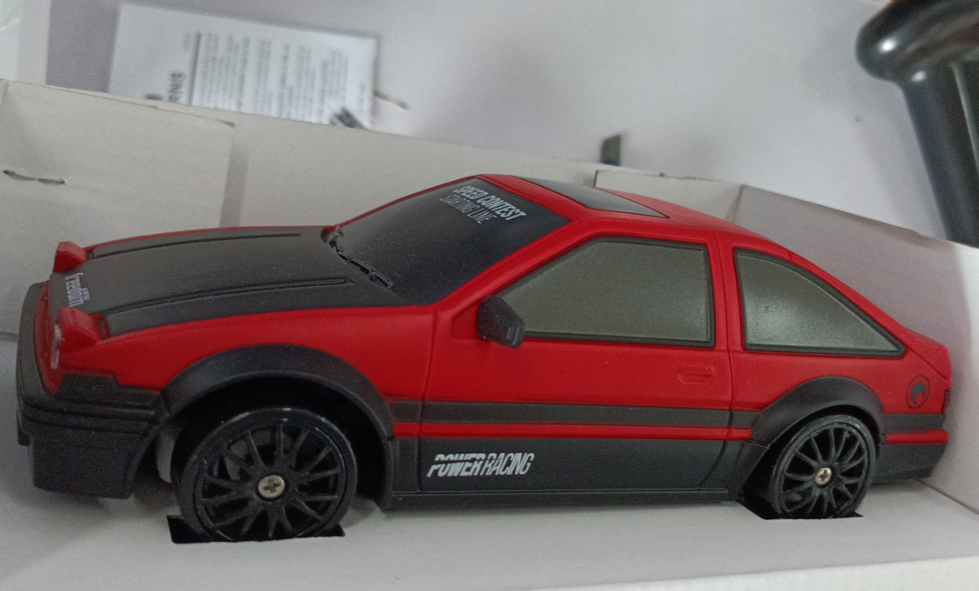Czerwone auto do driftu z pachołkami